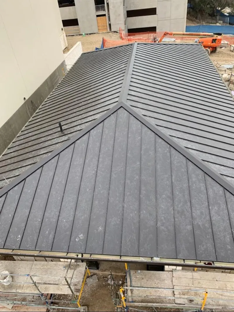 Commercial metal roof construction with crane equipment in Kerrville